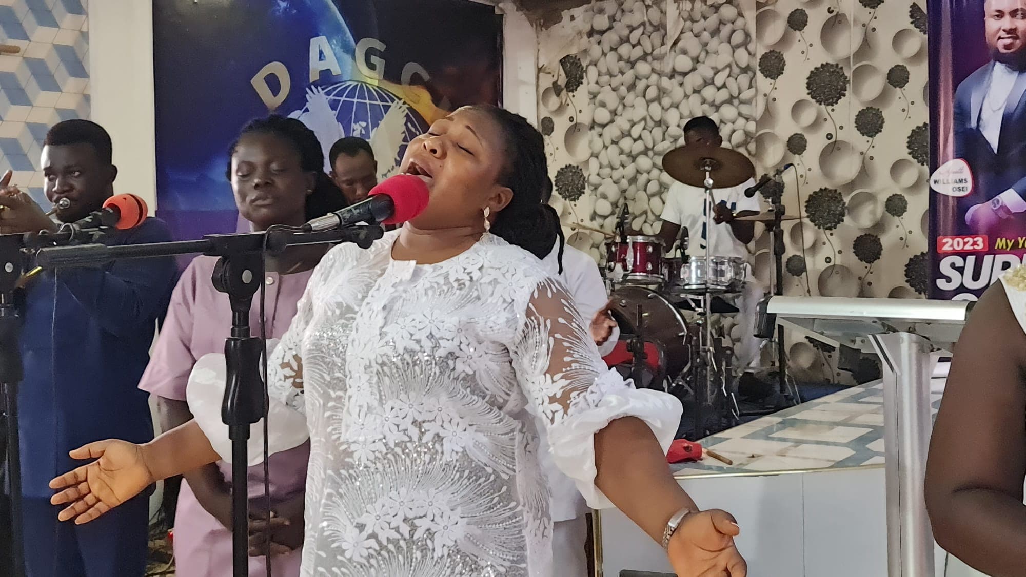 A worship leader singing on stage at DAG Foundation.